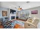 Cozy living room with a fireplace, TV, ceiling fan, plantation shutters and hardwood floors, ideal for relaxing at 18819 Sunterra Dr, Land O Lakes, FL 34638