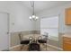 Bright breakfast nook with a charming chandelier and black iron table and chairs with decorative fabric seats at 5548 Cannonade Dr, Wesley Chapel, FL 33544