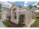 Side view of a tan home with a well maintained lawn and beautiful garden area at 5548 Cannonade Dr, Wesley Chapel, FL 33544