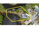 Aerial view highlighting the property's expansive lot, waterside location, screened enclosure, and lush landscaping at 5771 Catskill Rd, Holiday, FL 34690