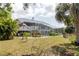 Expansive backyard with a screened-in porch, mature trees, and a well-maintained lawn at 5771 Catskill Rd, Holiday, FL 34690