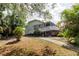 Two-story home with a ramp, screened porch, and lush landscaping at 5771 Catskill Rd, Holiday, FL 34690