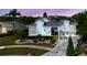 Charming two-story home featuring a well-manicured front yard, lake view, solar panels and inviting entrance at 5771 Catskill Rd, Holiday, FL 34690