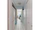 Hallway with a full-size refrigerator, white tile floors, and access to the laundry area at 5771 Catskill Rd, Holiday, FL 34690