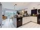 Well-lit kitchen boasting white cabinets, black appliances, and a view of the backyard at 5771 Catskill Rd, Holiday, FL 34690