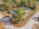 Aerial shot showcases a beautiful home with a fenced yard, mature tree, and screened-in pool at 7482 Winter St, Brooksville, FL 34613