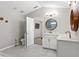 Bright bathroom featuring a single vanity, a round decorative mirror, brushed gold faucet, and toilet at 7482 Winter St, Brooksville, FL 34613