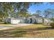 The exterior of the home includes an attached garage, solar panels and beautiful landscaping at 7482 Winter St, Brooksville, FL 34613