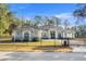 Beautiful single-story home featuring a black iron fence, well-manicured lawn, and a modern architectural design at 7482 Winter St, Brooksville, FL 34613
