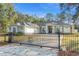 The home has an elegant gated entry, solar panels, beautiful landscaping, and a long driveway at 7482 Winter St, Brooksville, FL 34613