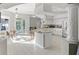 Spacious kitchen boasts an island with granite countertop, stainless steel appliances, and bright white cabinetry at 7482 Winter St, Brooksville, FL 34613