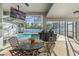 Relaxing screened-in patio with a dining table, grill, views of the sparkling pool and lush backyard at 7482 Winter St, Brooksville, FL 34613