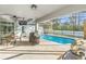 Inviting screened-in patio with a pool, outdoor dining area, grill, and relaxing ambiance for entertaining at 7482 Winter St, Brooksville, FL 34613