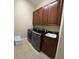 Functional laundry area featuring modern washer, dryer, storage cabinets and convenient utility sink at 1421 Apollo Beach Blvd, Apollo Beach, FL 33572