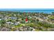 Aerial view of home near lush, green neighborhood with bay views in the distance at 1888 Douglas Ave, Dunedin, FL 34698