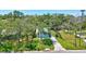 A scenic aerial shot reveals a well-placed home with a large lawn, shaded by mature trees at 1888 Douglas Ave, Dunedin, FL 34698