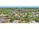 A captivating aerial perspective of a home nestled amongst a dense, mature tree canopy at 1888 Douglas Ave, Dunedin, FL 34698