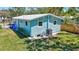 Backyard of home with lush green grass and shade with fenced-in yard at 1888 Douglas Ave, Dunedin, FL 34698