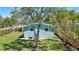 Quaint backyard offering a lush green lawn and mature trees at 1888 Douglas Ave, Dunedin, FL 34698