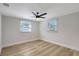 A bright bedroom with neutral walls, light wood-look flooring, and two windows for natural light at 1888 Douglas Ave, Dunedin, FL 34698