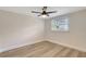 Bright bedroom featuring light-colored wood floors, a ceiling fan, and a window with blinds at 1888 Douglas Ave, Dunedin, FL 34698