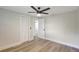 Bedroom with wood floors, a ceiling fan, closet, and a white door leading to another room at 1888 Douglas Ave, Dunedin, FL 34698