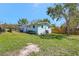 Exterior view of a light blue home with white trim, fenced yard, and a well-maintained lawn at 1888 Douglas Ave, Dunedin, FL 34698