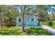 Charming single-story home with a neatly kept front lawn, framed by mature trees offering ample shade at 1888 Douglas Ave, Dunedin, FL 34698