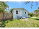Charming home with white door and shutters, well-maintained front yard, and wood and iron fence at 1888 Douglas Ave, Dunedin, FL 34698