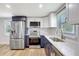 Modern kitchen featuring stainless steel appliances, subway tile backsplash, and white and navy blue cabinetry at 1888 Douglas Ave, Dunedin, FL 34698