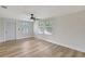 Bright living room featuring modern ceiling fan, fresh paint, wood floors, and natural light at 1888 Douglas Ave, Dunedin, FL 34698