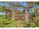 Hammock Park sign surrounded by green grass, trees, and palm trees on a sunny day at 1888 Douglas Ave, Dunedin, FL 34698