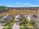 Aerial view of a single-story home with solar panels, a landscaped yard and a lush field in the background at 2109 Trillium Blvd, Brooksville, FL 34604