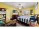 Bright bedroom with a ceiling fan, laminate flooring, a large bed, and a window overlooking the backyard at 2109 Trillium Blvd, Brooksville, FL 34604