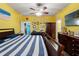 A spacious bedroom boasts bright yellow walls, a ceiling fan, hard surface floors, and comfortable furnishings at 2109 Trillium Blvd, Brooksville, FL 34604