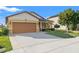 Charming single-story home with a well-manicured lawn, mature tree, and two-car garage in a residential neighborhood at 2109 Trillium Blvd, Brooksville, FL 34604