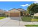 Charming single-story home with a well-manicured lawn, mature tree, and two-car garage in a residential neighborhood at 2109 Trillium Blvd, Brooksville, FL 34604