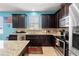Kitchen featuring stainless steel appliances, dark cabinetry, a breakfast bar, and blue accent wall at 2109 Trillium Blvd, Brooksville, FL 34604