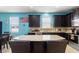 A kitchen features granite countertops, modern appliances, dark cabinets, a tile backsplash and a breakfast bar with stools at 2109 Trillium Blvd, Brooksville, FL 34604