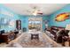 Inviting living room featuring a ceiling fan, comfortable seating, a glass coffee table, and sliding doors to a screened lanai at 2109 Trillium Blvd, Brooksville, FL 34604
