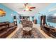 Cozy living room with a ceiling fan, comfortable couches, a glass-topped coffee table, and an open view to the kitchen at 2109 Trillium Blvd, Brooksville, FL 34604