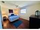 Cozy bedroom with ceiling fan, laminate floors, and ample natural light at 3523 Cambridge St, New Port Richey, FL 34652