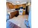 Well-lit kitchen with wooden cabinetry, tile floors and updated appliances at 3523 Cambridge St, New Port Richey, FL 34652