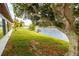 Waterfront backyard featuring lush lawn and mature trees at 3526 Overland Dr, Holiday, FL 34691