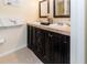 Bathroom with dual sinks, dark wood cabinets, and marble countertop at 3526 Overland Dr, Holiday, FL 34691