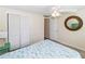 Cozy bedroom with a ceiling fan, closet, and round mirror to add natural light and extra space at 3526 Overland Dr, Holiday, FL 34691