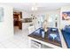 Bright dining room with wooden table set for four and white tile floors at 3526 Overland Dr, Holiday, FL 34691