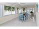 Bright dining area with tile flooring, large windows overlooking the water, and a dining table with blue chairs at 3526 Overland Dr, Holiday, FL 34691