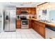 Efficient kitchen with stainless appliances, warm wood cabinetry, and ample countertop space at 3526 Overland Dr, Holiday, FL 34691