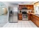 Well-equipped kitchen with stainless steel appliances, wood cabinets, and tile flooring at 3526 Overland Dr, Holiday, FL 34691